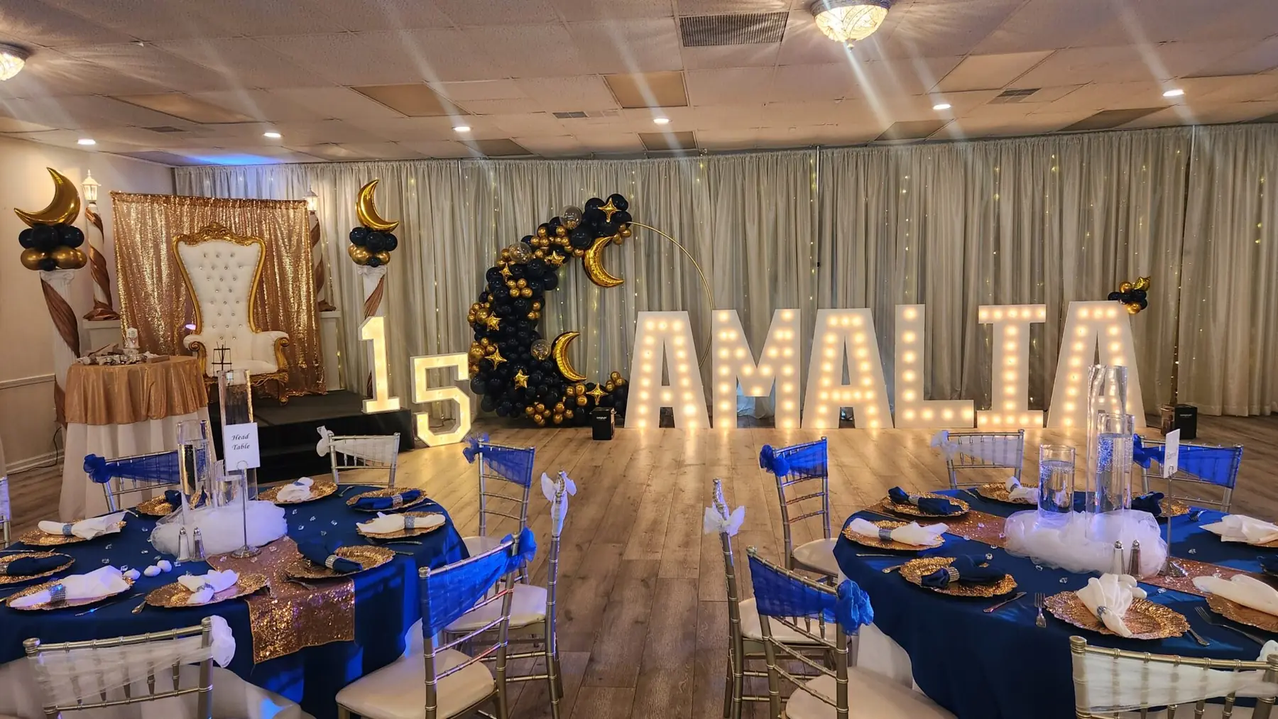 A quinceañera with marquee letters and navy linens